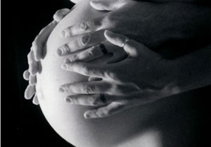 Photo of hands on pregnant belly